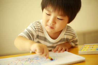 Evde çizim yapan bir çocuk resmi