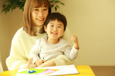 Genç anne ve tatlı küçük oğlu evde birlikte zaman geçirip, eğitim oyunları oynuyorlar.