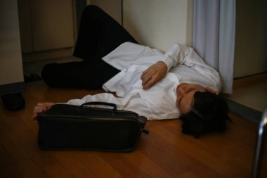 Yerde uyuyan sarhoş adam.