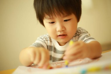 Güzel çocuk evde resim çiziyor.