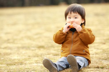 küçük çocuk parkta yemek 