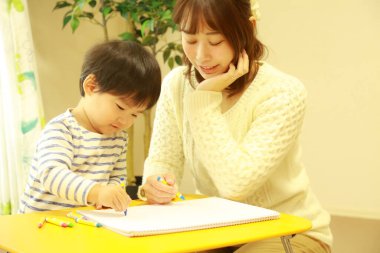 Genç anne ve tatlı küçük oğlu evde birlikte zaman geçirip, eğitim oyunları oynuyorlar.