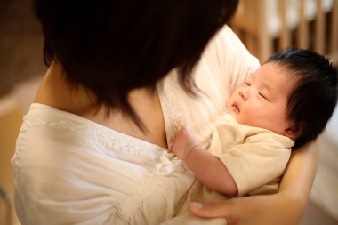 Yeni doğmuş bir bebek ve gülümseyen bir anne.