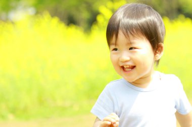 Parkta gülümseyen sevimli Asyalı çocuk. 