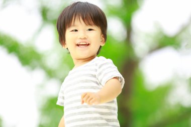 Parkta duran sevimli Asyalı çocuk. 