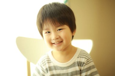 Kameraya gülümseyen sevimli bir çocuğun portresi.