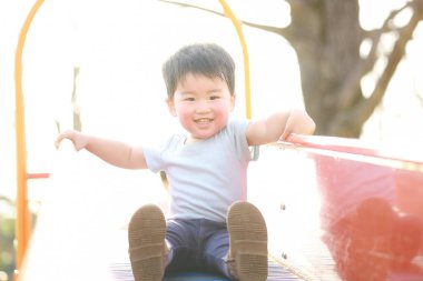 Küçük çocuk parkta oyun oynuyor.