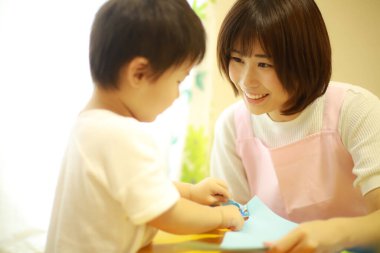 Genç Asyalı anne küçük oğluyla oynuyor.