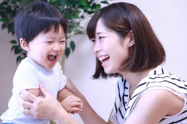 Mutlu Asyalı anne oğlunu pirinçle besliyor.