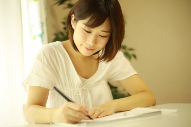 Bir kağıda yazı yazan genç bir kadının yakın çekimi.