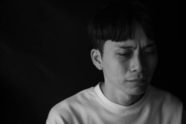 Üzgün Asyalı adam içeride ağlıyor.