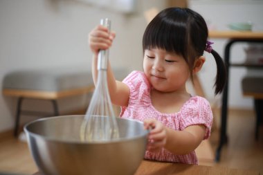 Mutfakta yemek pişiren tatlı küçük kız..