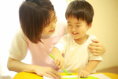 Annesiyle resim yapan küçük sevimli bir çocuk. 