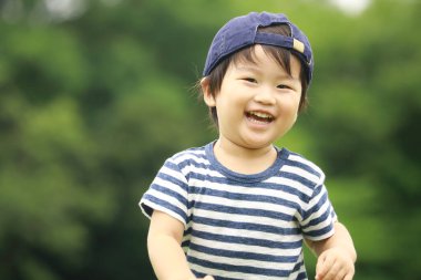 Parktaki yakışıklı Asyalı çocuk.