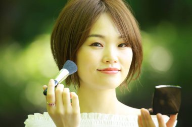 Parkta fırçası olan genç, güzel Asyalı kadın. 