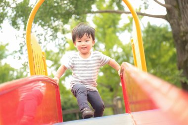 Asyalı küçük çocuk oyun alanında eğleniyor.