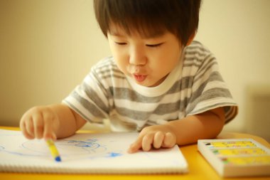 Evde çizim yapan bir çocuk resmi