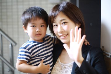 Mutlu Asyalı anne ve oğul kamera önünde poz veriyor.