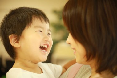 Genç Asyalı anne küçük oğluyla oynuyor.