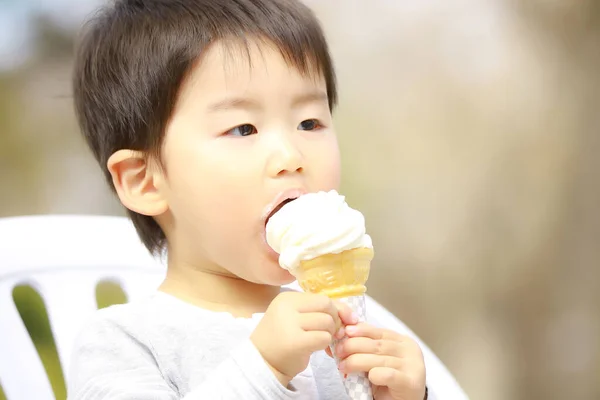 公園でアイスクリームを食べるかわいい男の子 — ストック写真