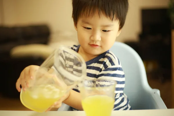 Niño Pequeño Vertiendo Jugo Vaso —  Fotos de Stock