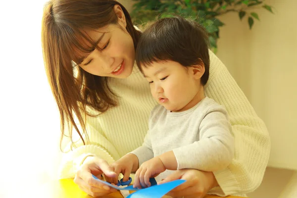 幼い母親とかわいい息子が家で一緒に教育ゲームをしたり — ストック写真