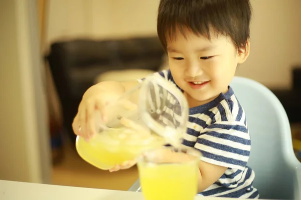 Χαριτωμένο Μικρό Αγόρι Ρίχνει Χυμό Στο Γυαλί — Φωτογραφία Αρχείου