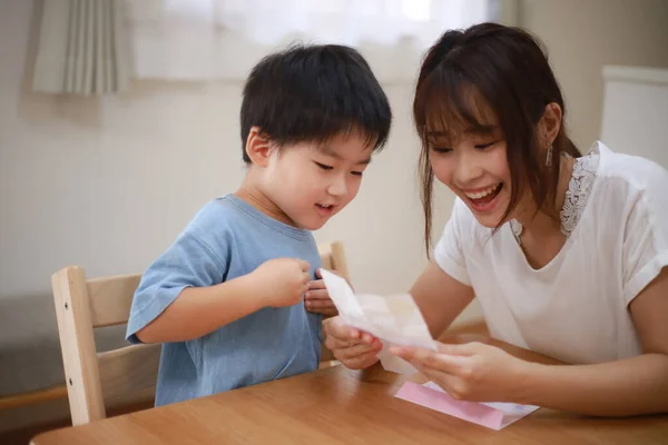 Junge Asiatische Mutter Mit Ihrem Sohn Hause Lesen Brief — Stockfoto