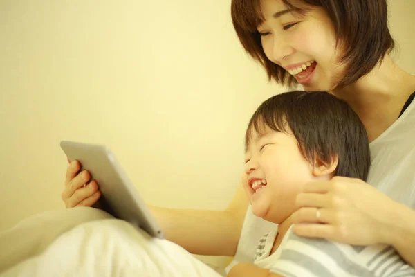 快乐的母子观看数码平板电脑上的视频 — 图库照片