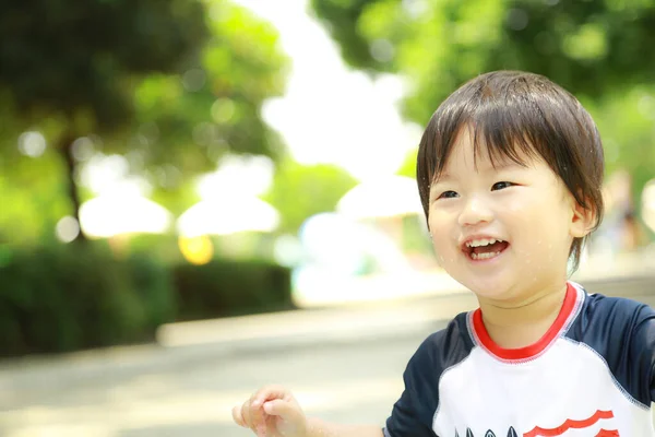 屋外の公園で笑うアジア系の男の子 — ストック写真