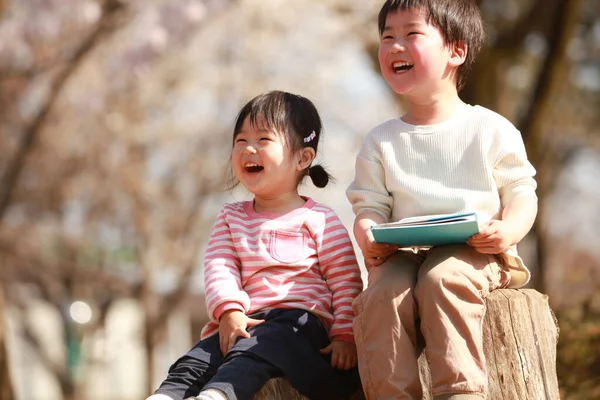 公園に座って本を読んでいる男の子と女の子 — ストック写真