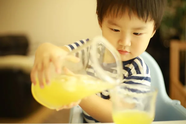 Милий Маленький Хлопчик Наливає Сік Склянку — стокове фото