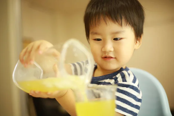 Азіатська Дитина Наливає Сік Склянку — стокове фото