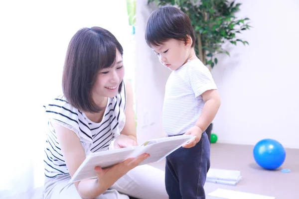 Krásná Asijská Žena Čtení Knihy Svým Malým Synem — Stock fotografie