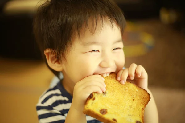 Азиатский Мальчик Ест Тосты Кухне — стоковое фото