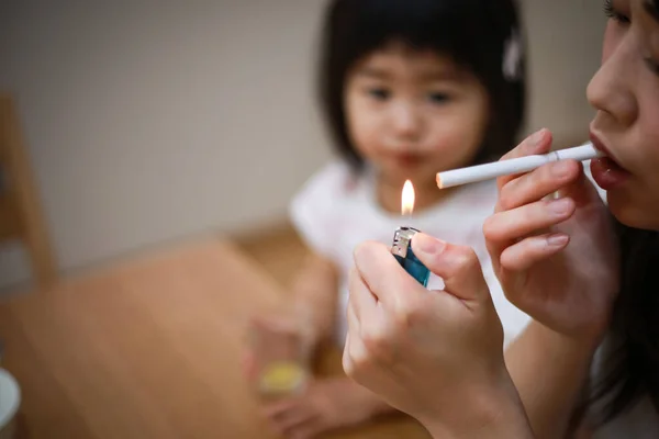 Image of a mother smoking near her child