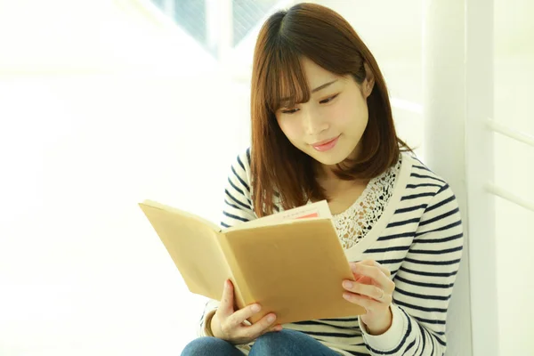 美丽的年轻亚洲女人在看书 — 图库照片