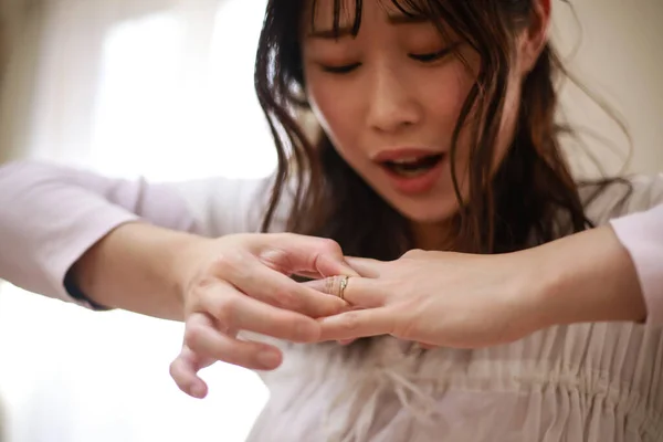 若いアジア系女性が指輪を外し — ストック写真