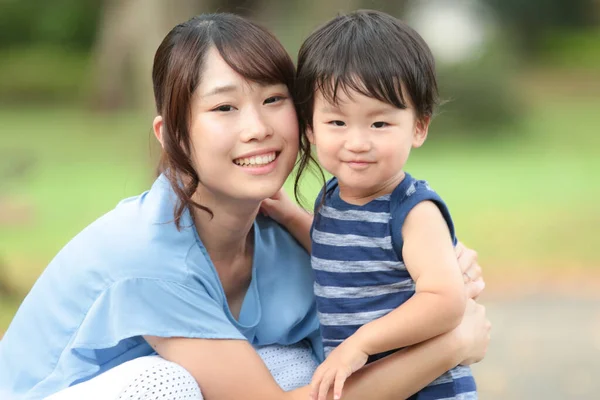 公園で彼女の子供を持つ若いアジアの女性 — ストック写真