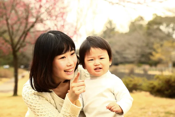Młoda Azjatycka Matka Pokazuje Coś Swojemu Dziecku Parku — Zdjęcie stockowe