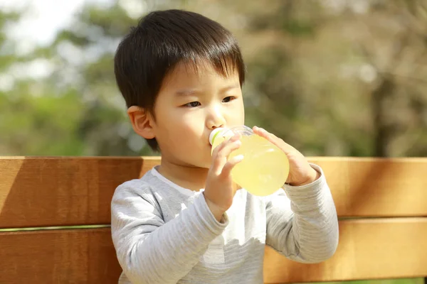 Азиатский Мальчик Пьет Бутылки Парке — стоковое фото