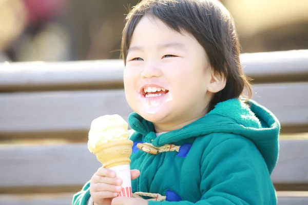 公園でアイスクリームを食べるかわいい男の子 — ストック写真