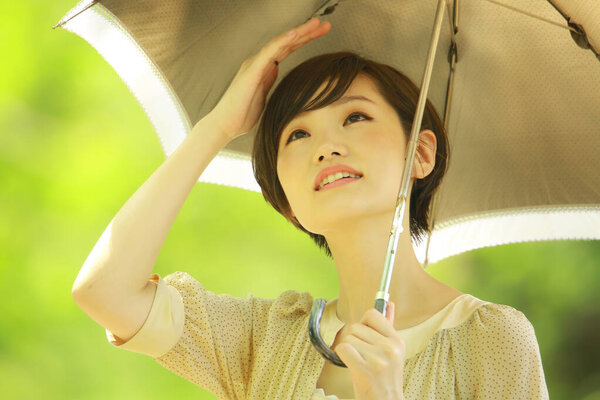 Portrait of young asian woman withumbrella in the park