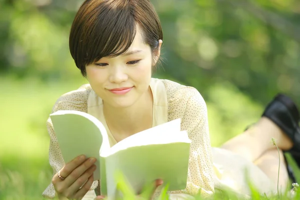 在公园看书的年轻亚洲女人的肖像 — 图库照片