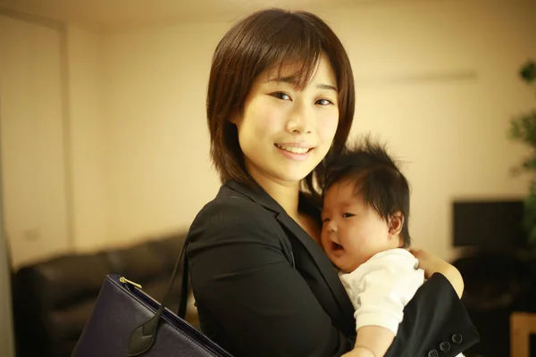 Resmi Giyinmiş Genç Asyalı Kadını Evde Küçük Sevimli Bir Bebeği — Stok fotoğraf