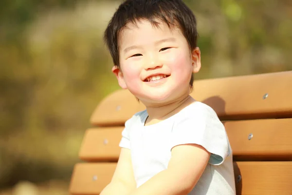 Roztomilý Chlapec Sedí Lavičce Parku — Stock fotografie