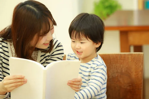 Młoda Matka Uroczym Synkiem Czytającym Książkę Razem Domu — Zdjęcie stockowe