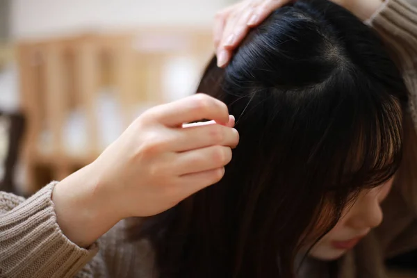 年轻的亚洲女人看着镜子 试着在头上找到灰白的头发 — 图库照片