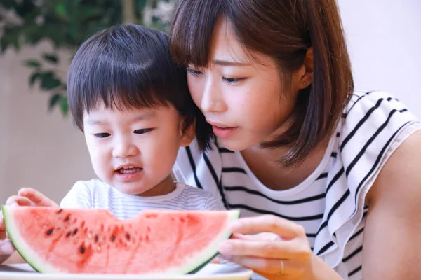 Jovem Mãe Alimentando Seu Filho Com Melancia Fresca — Fotografia de Stock