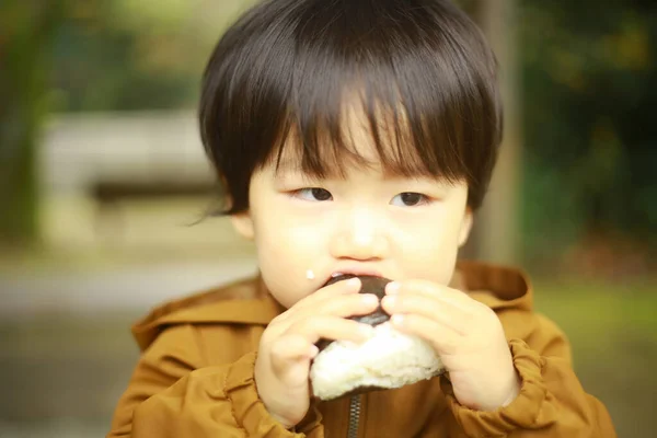 Parktaki Küçük Asyalı Çocuk Yemek Yiyor — Stok fotoğraf